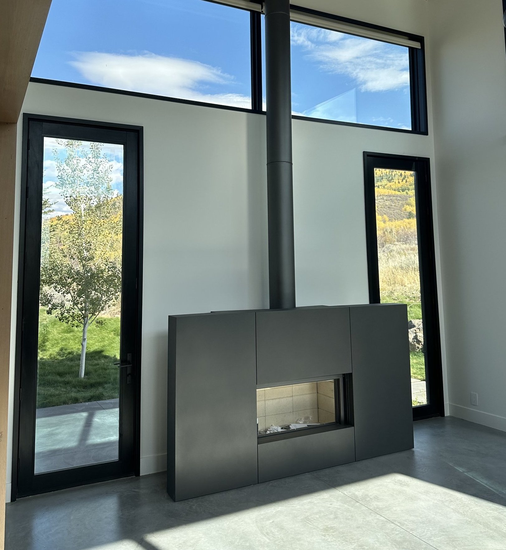 Completed modern freestanding gas fireplace installation in a luxury new construction Teton County home with mountain views